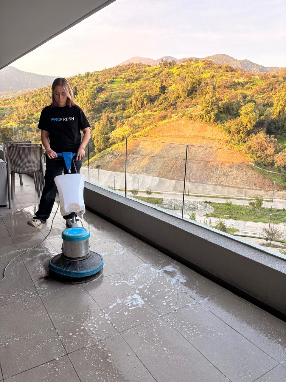 Integrante del equipo de Profresh limpiando los pisos de una terraza