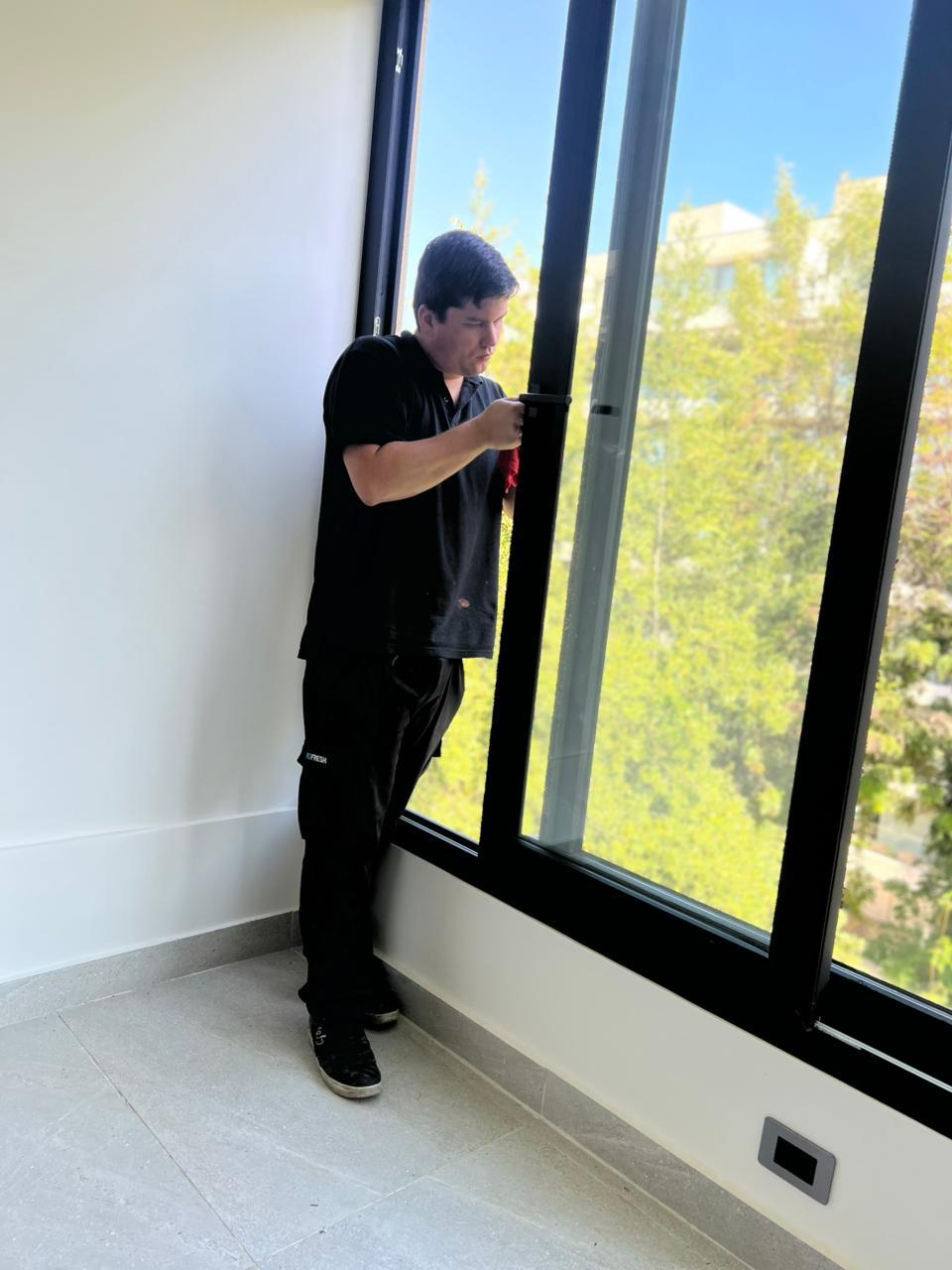Integrante del equipo de Profresh limpiando ventanas en un departamento